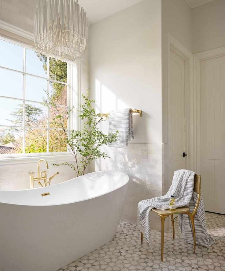 bathroom with freestanding tub and patterned tiles with large window