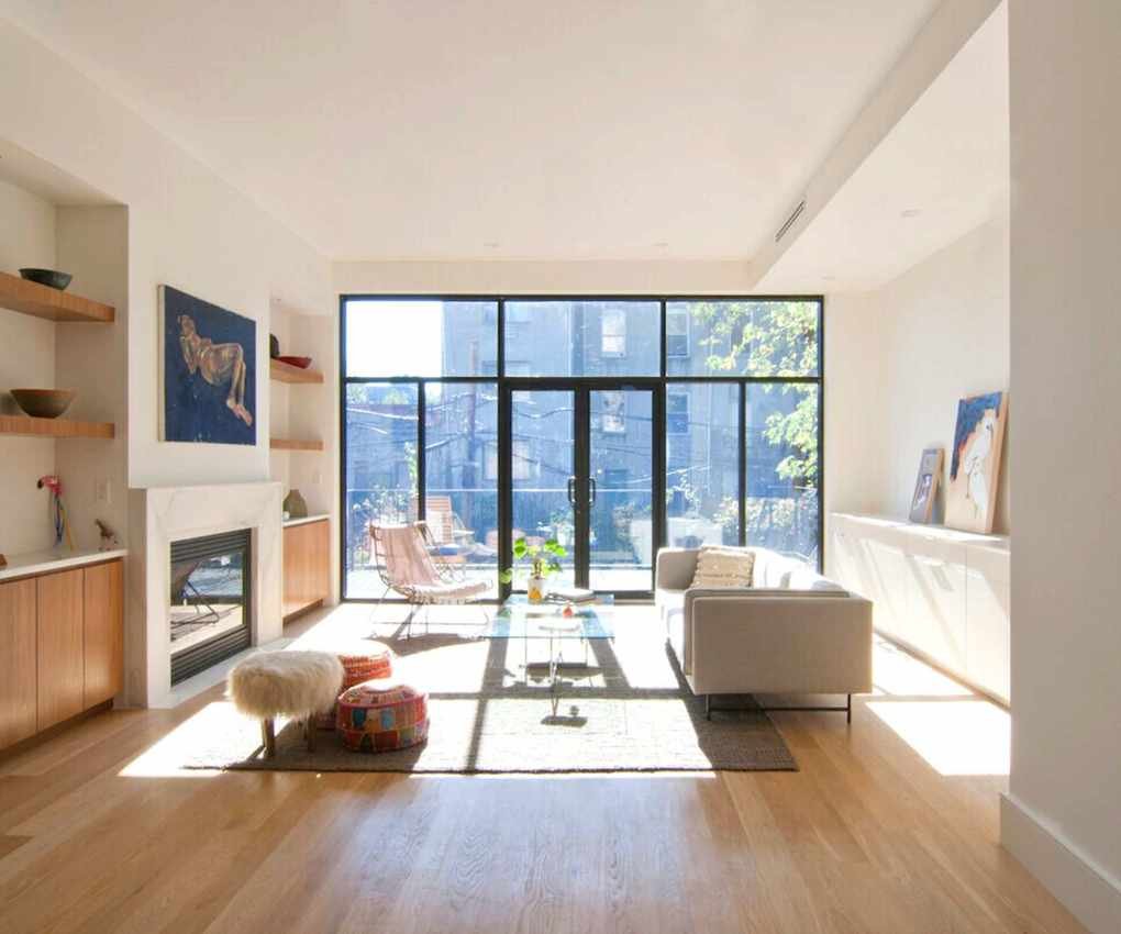 Neutral living room with floor to ceiling window and door leading to balcony
